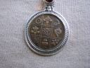 Lrkes amulet med en mnt fra Bhutan